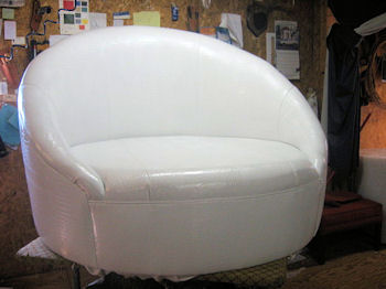 Round style modern chair upholstered in vinyl naugahyde