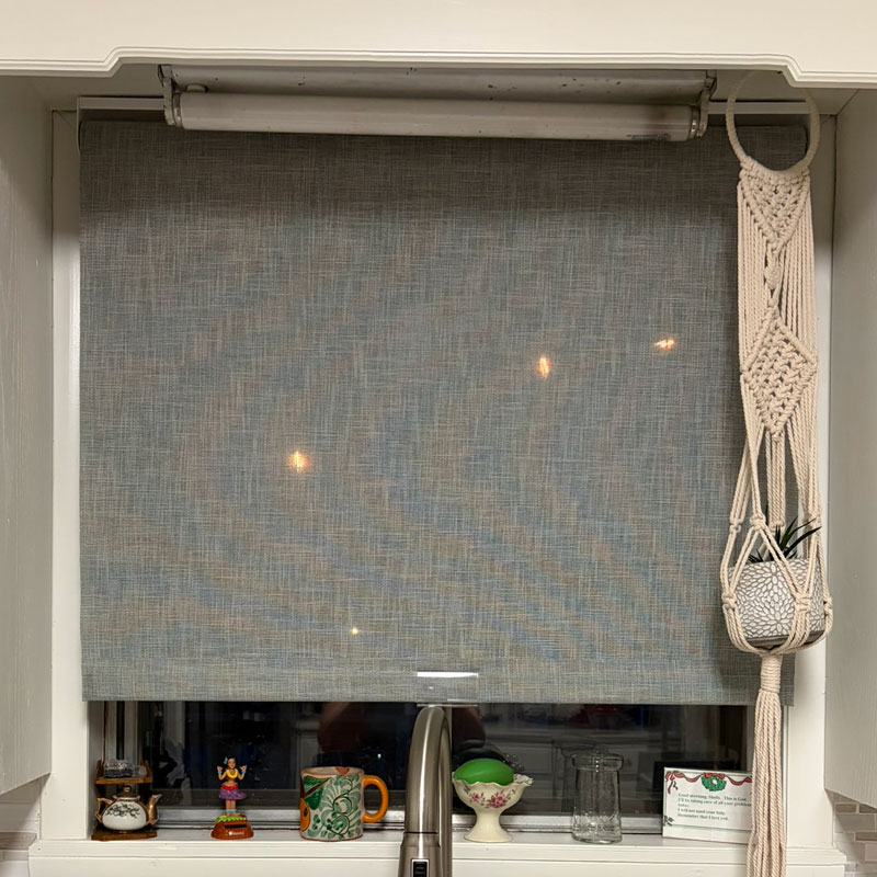 Finished gray linen look cordless roller shade, inside mount over a kitchen sink